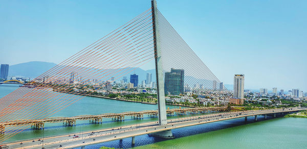 Bridge over river in city against clear sky