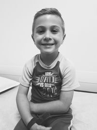 Portrait of happy boy sitting on sofa