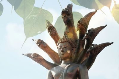 Low angle view of buddha statue against sky