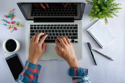 Low section of person using laptop on table