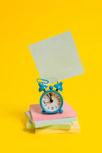 Close-up of clock on yellow background