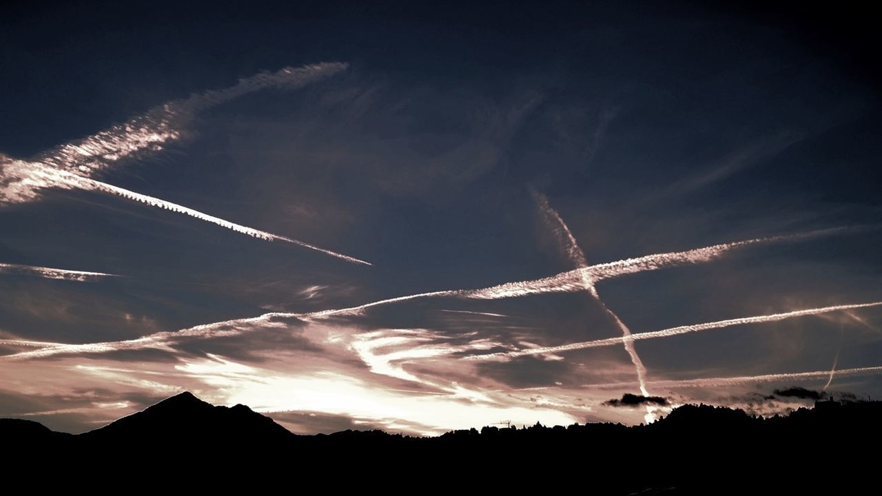 sky, scenics, silhouette, beauty in nature, sunset, tranquil scene, mountain, building exterior, nature, cloud - sky, tranquility, landscape, built structure, architecture, idyllic, vapor trail, tree, outdoors, city, no people