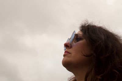 Woman in sunglasses looking away against sky