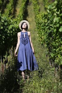 Full length of young woman standing in vineyard