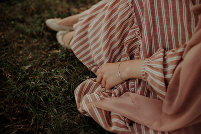 Low section of woman sitting on grass