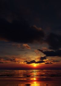 Scenic view of sea against dramatic sky during sunset