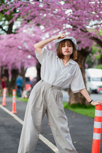 Full length of woman standing by pink flower