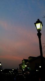 Low angle view of illuminated street light against sky at dusk