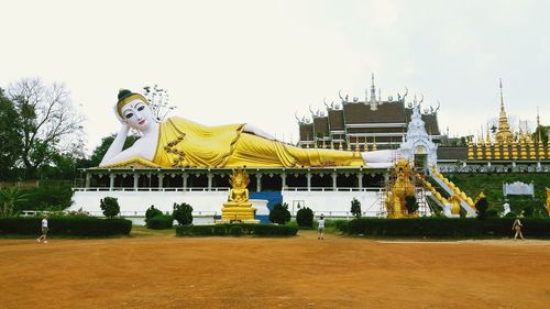 Statue against temple building against clear sky