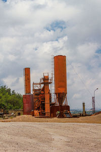 Rusty metallic structure on field against sky