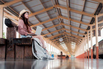 Woman sitting on ceiling of building