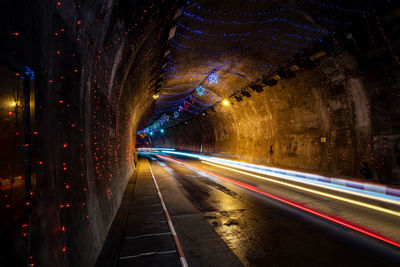 Light trails on road in illuminated tunnel