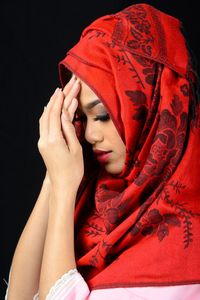 Portrait of woman with red hair against black background
