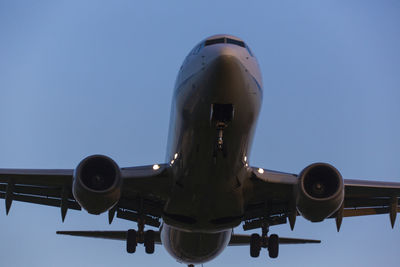 Low angle view of airplane against clear blue sky