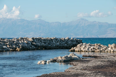 Scenic view of sea and mountains against sky