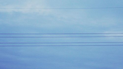 Low angle view of cables against blue sky