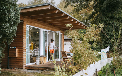 Mature man standing at doorway of tiny house