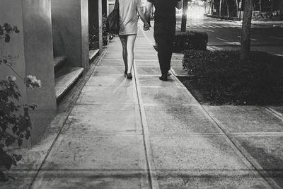 Low section of women standing on zebra crossing