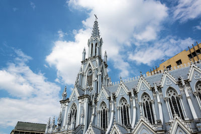 Low angle view of bell tower against cloudy sky