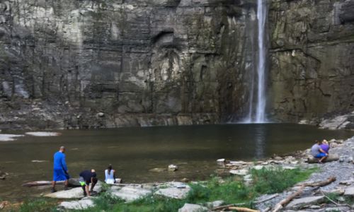 People on rocks by waterfall