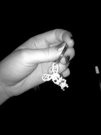 Close-up of hand holding flower over white background