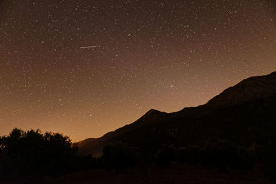 Scenic view of silhouette mountain against sky at night
