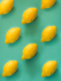 High angle view of yellow eggs against blue background