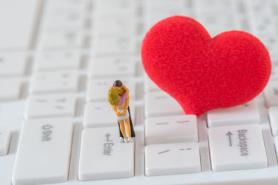 Close-up of heart shape and figurines on keyboard