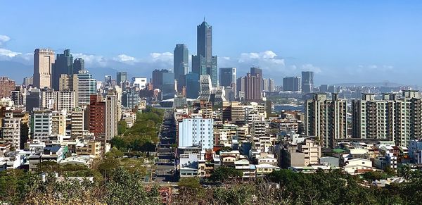 Aerial view of buildings in city against sky