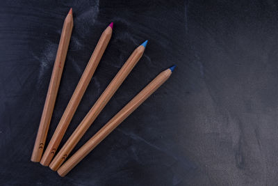 High angle view of pencils on table against black background