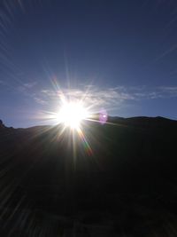 Low angle view of bright sun in sky