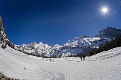 Scenic view of snowcapped mountains against blue sky