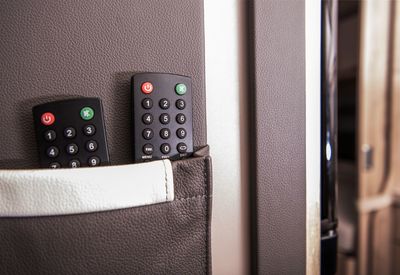 Close-up of remote controls against wall at home