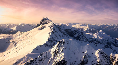 Scenic view of snowcapped mountains against sky during sunset