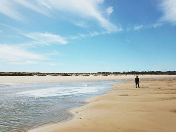 Man at beach against sky