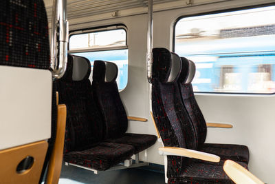 View on railroad track from the window of fast train. interior view at train's empty window seat