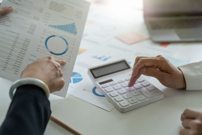 Midsection of businessman working on table