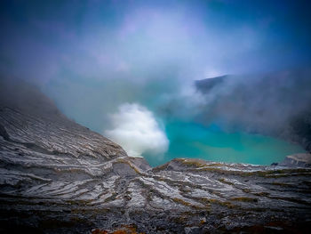 Smoke emitting from volcanic mountain against sky