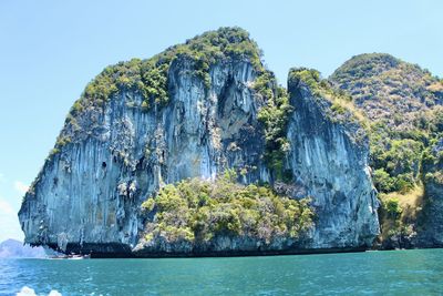 Panoramic view of rock formation in sea against clear sky