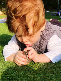 Full length of cute baby boy holding grass