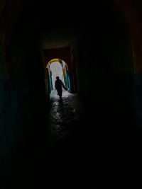 Silhouette man standing in tunnel