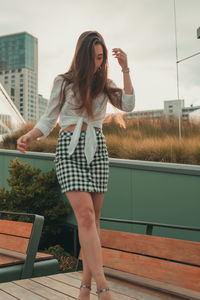 Young woman standing outdoors against sky