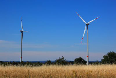 Windmill on field against sky