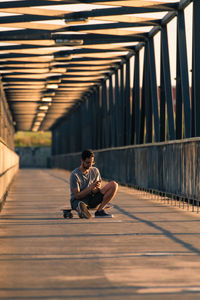 Side view of man sitting on street