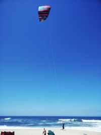 Scenic view of beach against clear blue sky