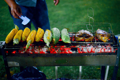 Midsection of man preparing food on barbecue grill