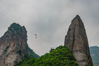 Low angle view of rock formation against cloudy sky