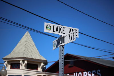 Low angle view of information sign against clear blue sky