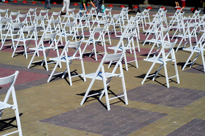 Folding chairs are arranged on recreation area. empty folding wooden chairs in a public square 