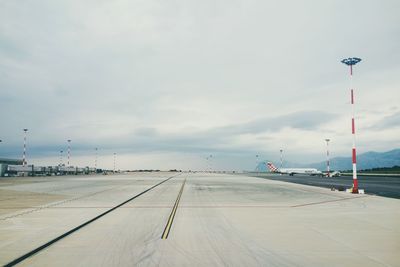 Street lights on airport runway against sky